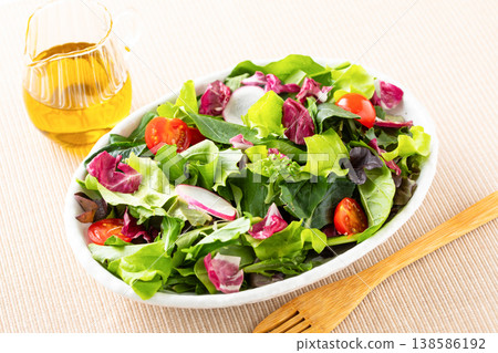 桌上擺著蔬菜沙拉和橄欖油。 138586192
