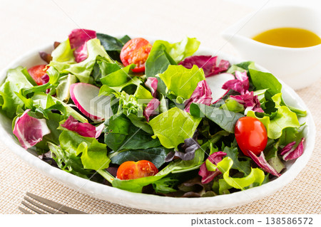 桌上擺著蔬菜沙拉和橄欖油。 138586572