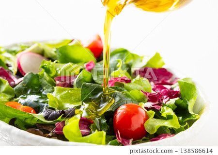 在蔬菜沙拉上淋上橄欖油。 138586614