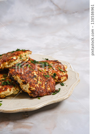Fish patties served on a platter with herbs in a simple kitchen setting Fish patties served on a platter with herbs in a simple kitchen setting 138586961