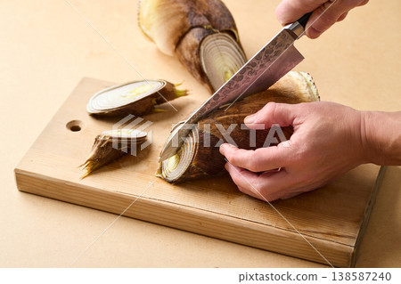 Make cuts in the bamboo shoot with a knife. 138587240