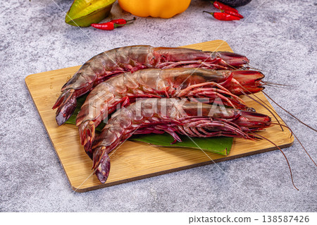 Fresh raw giant red prawns on a plate with chili peppers and tropical vegetables. Fresh raw giant red prawns on a plate with chili peppers and tropical vegetables. 138587426