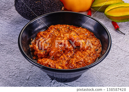 Indian butter chicken masala, a spicy traditional curry served in a bowl on a textured background. Indian butter chicken masala, a spicy traditional curry served in a bowl on a textured background. 138587428