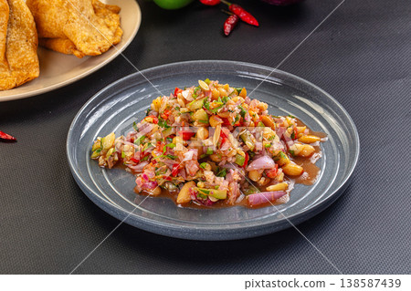 Spicy peanut and red onion salsa with cilantro and chili, served with fried chips. Spicy peanut and red onion salsa with cilantro and chili, served with fried chips. 138587439