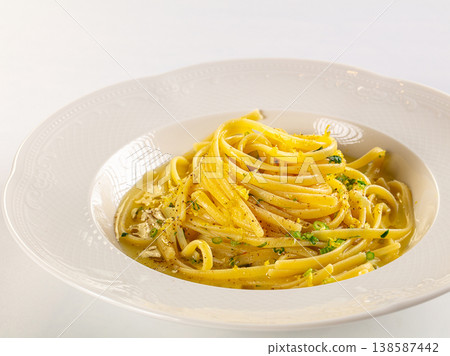 Italian linguine pasta with creamy lemon sauce and herbs in an elegant white bowl, isolated on a white background. 138587442