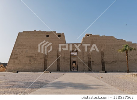 麥地那哈布神廟正面圖——一座宏偉的古代建築,以其軸線為指導。 麥地那哈布神廟正面圖——一座宏偉的古代建築,以其軸線為指導。 138587562