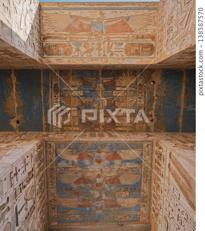 Painted ceiling frescoes in the Medinet Habu Temple—decorative motifs of a winged god Painted ceiling frescoes in the Medinet Habu Temple—decorative motifs of a winged god 138587570