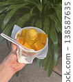 A woman's hand holding a mango parfait 138587635