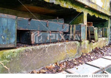 Weathered wooden ammunition crates stacked in a concrete bunker, remnants of the Vietnam War era 138587780