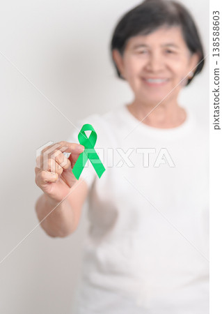 Elderly with Green Ribbon for concept of April Donate Life month, Organ Donation and Transplant Awareness, May Mental Health Awareness month and October Liver cancer. Health and world cancer day Elderly with Green Ribbon for concept of April Donate Life month, Organ Donation and Transplant Awareness, May Mental Health Awareness month and October Liver cancer. Health and world cancer day 138588603