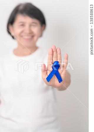 Elderly with dark Blue or Navy blue Ribbon for concept of March Colorectal and Colon Cancer Awareness month, May Arthritis awareness, July Juvenile arthritis and Childhood. Health and world cancer day Elderly with dark Blue or Navy blue Ribbon for concept of March Colorectal and Colon Cancer Awareness month, May Arthritis awareness, July Juvenile arthritis and Childhood. Health and world cancer day 138588613