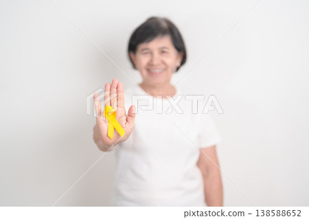 Elderly with Yellow Ribbon for concept of yellow September, Suicide prevention day, Childhood, July Sarcoma, bone and bladder cancer Awareness month, support survivor. Healthcare and World Cancer day 138588652