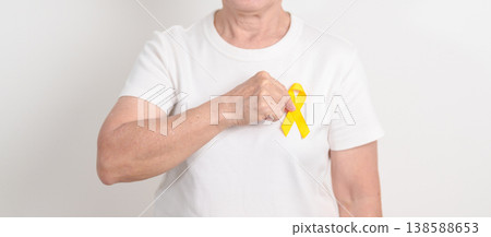 Elderly with Yellow Ribbon for concept of yellow September, Suicide prevention day, Childhood, July Sarcoma, bone and bladder cancer Awareness month, support survivor. Healthcare and World Cancer day 138588653