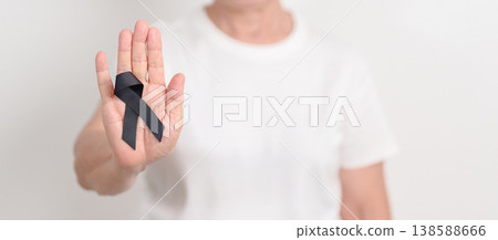Elderly with Black ribbon for May Melanoma and skin cancer Awareness month, October Vaccine injury awareness month, Mourning Remembrance, March Sleep awareness week, Gang Prevention and Anti Violence 138588666