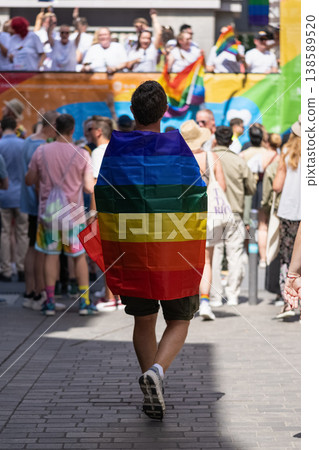 Person wrapped in rainbow flag walking Person wrapped in rainbow flag walking 138589520