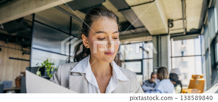 White analyst studying quarterly report in industrial office White analyst studying quarterly report in industrial office 138589840