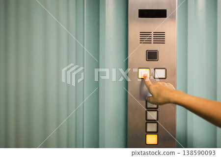 Close up of a hand pressing button on elevator control panel. Close up of a hand pressing button on elevator control panel. 138590093