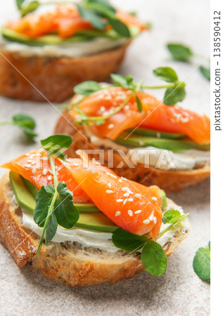 Savory salmon avocado bruschetta with microgreens and sesame seeds 138590412