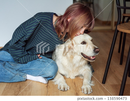 Young woman showing affection to golden retriever dog 138590473