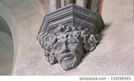 Stone carved face sculpture detail on gothic column inside Malbork Castle in Poland. Architecture, history and heritage concept 138590485