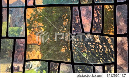 Close view of ancient stained glass window inside Malbork Castle in Poland showing textured panes and abstract patterns with exterior light. Architecture, history and heritage concept 138590487