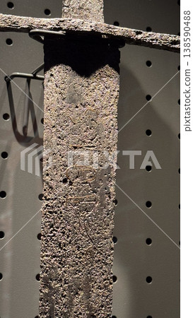Close up of corroded medieval sword blade with visible texture and marks displayed in museum in Malbork Castle Poland. Detail, material and history concept Close up of corroded medieval sword blade with visible texture and marks displayed in museum in Malbork Castle Poland. Detail, material and history concept 138590488