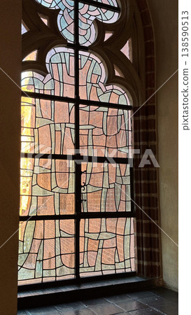 Ancient stained glass window with geometric pattern and gothic arch inside Malbork Castle in Poland. Architecture, history and heritage concept 138590513
