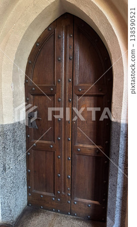 Ancient wooden door with metal studs and arched stone frame inside Malbork Castle in Poland. Architecture, history and heritage concept Ancient wooden door with metal studs and arched stone frame inside Malbork Castle in Poland. Architecture, history and heritage concept 138590521