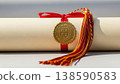 Rolled university diploma with gold seal, red ribbon and tassel on neutral background, symbolizing graduation, achievement and academic success 138590583
