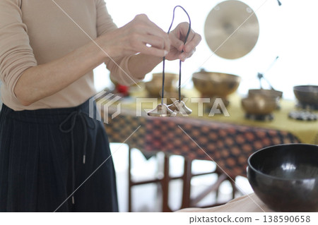 A woman ringing a tingsha bell. A woman ringing a tingsha bell. 138590658