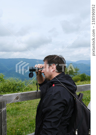 Hiker Looks Through Monocular at Mountains Hiker Looks Through Monocular at Mountains 138590952