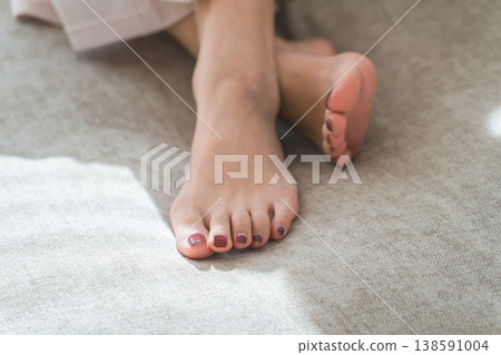一位女士光著的、做了足療的雙腳放在沙發上。 一位女士光著的、做了足療的雙腳放在沙發上。 138591004