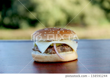 Delicious pork hamburger with cheese and panned cucumbers. Pork meat in burger Delicious pork hamburger with cheese and panned cucumbers. Pork meat in burger 138591244