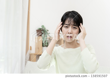 Young woman with a headache; headache; migraine. 138591507