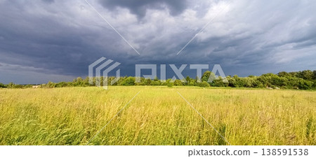 Landscape with thundercloud over green field. Storm clouds above summer field Landscape with thundercloud over green field. Storm clouds above summer field 138591538