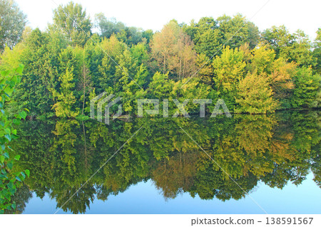 Landscape with river in autumn. Trees are reflected in water of river Landscape with river in autumn. Trees are reflected in water of river 138591567
