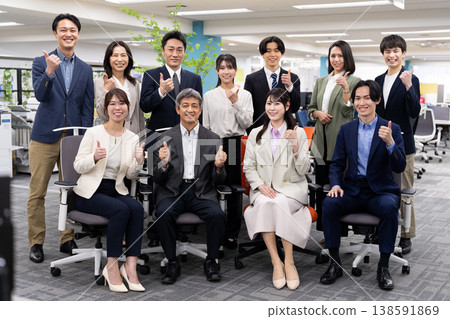 一張商務團隊的合影，大家都在明亮的辦公室裡笑容滿面。 138591869