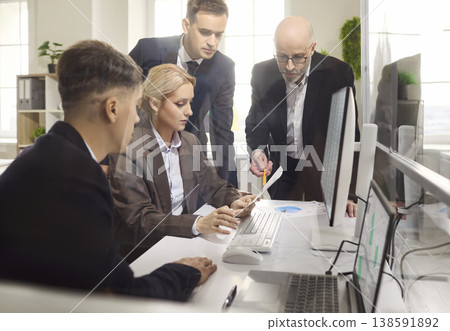 Business colleagues reviewing tablet and charts during strategy meeting in office Business colleagues reviewing tablet and charts during strategy meeting in office 138591892