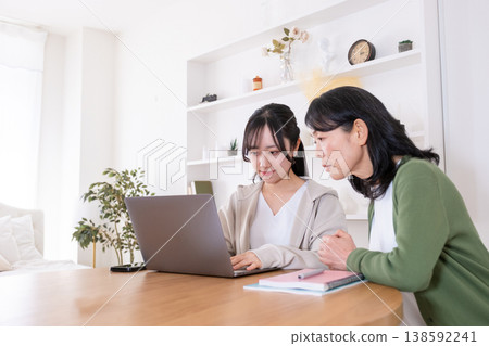 一對母女看著電腦螢幕，神情焦慮。 138592241