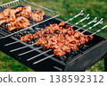 Pork skewers and chicken feet marinated grilling on rack over coals, spring barbecue in backyard 138592312