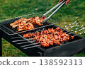 Pork skewers and chicken feet marinated grilling on rack over coals, spring barbecue in backyard 138592313