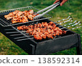 Pork skewers and chicken feet marinated grilling on rack over coals, spring barbecue in backyard 138592314