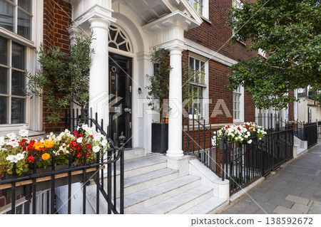 Elegant brick townhouse exterior with white pillars and flower boxes Elegant brick townhouse exterior with white pillars and flower boxes 138592672
