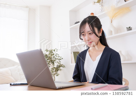 A woman in her 20s looks intently at her PC. A woman in her 20s looks intently at her PC. 138592781