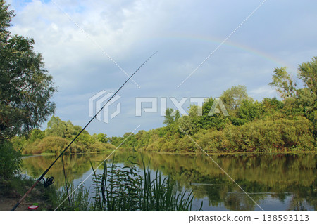 Landscape with rainbow over the river. Fishing with feeder. Summer panorama 138593113