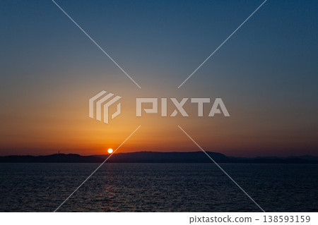 The horizon and the rising sun, the sea enveloped in silence. 138593159