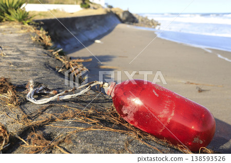 A red resin buoy washed ashore on the beach A red resin buoy washed ashore on the beach 138593526