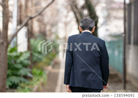 從背後拍攝的一位正在行走的商人。 138594091