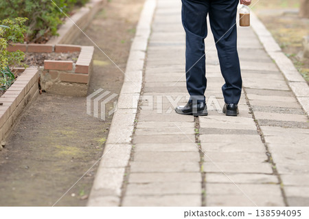 一位商人正在行走，鏡頭從背後拍攝，只拍到他的腳。 138594095