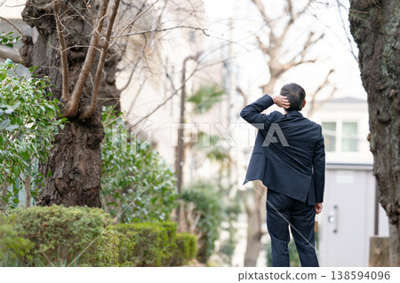 A businessman walking, seen from behind. 138594096